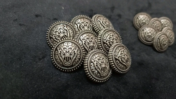 12 round metal buttons in gold and black. They have an embossed design and a shank on the back. Six buttons are larger, and six are smaller. These buttons can be used for coats, blazers, suits, sherwanis, and other Indian dresses. 