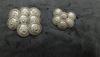 12 round metal buttons in gold and black. They have an embossed design and a shank on the back. Six buttons are larger, and six are smaller. These buttons can be used for coats, blazers, suits, sherwanis, and other Indian dresses. 