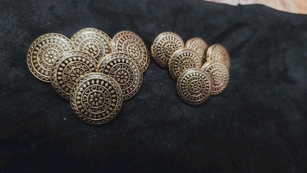 12 round metal buttons in gold and black. They have an embossed design and a shank on the back. Six buttons are larger, and six are smaller. These buttons can be used for coats, blazers, suits, sherwanis, and other Indian dresses. 